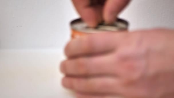 Défocalisation. un homme ouvre une boîte de conserve — Video