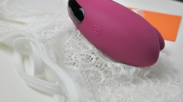 Der klitorale Scheidenvibrator dreht sich auf einer weißen Platte — Stockvideo