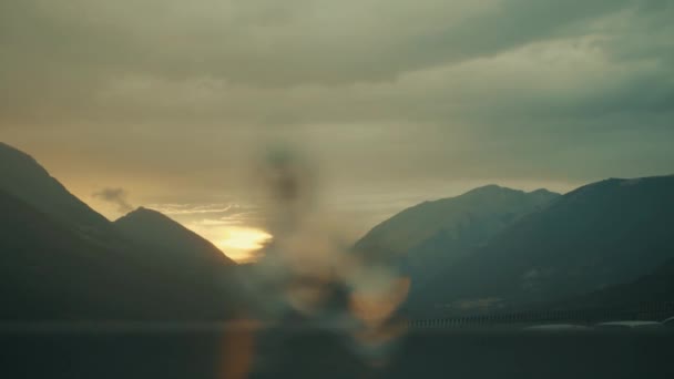 Fontän på en bakgrund av solnedgång i bergen. närbild av suddig fontän i förgrunden — Stockvideo