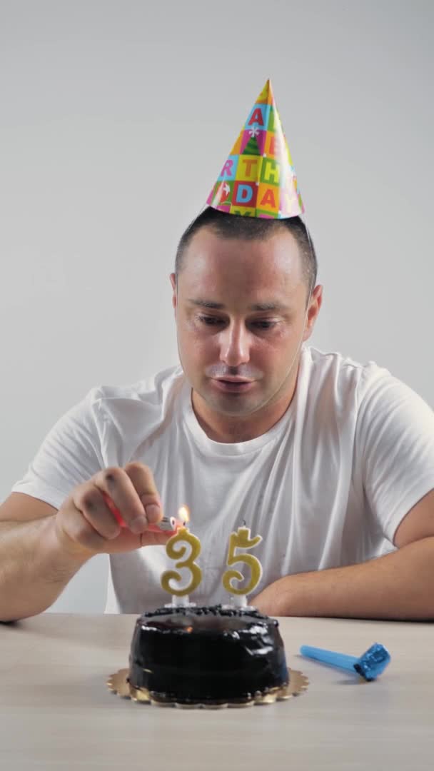 Pionowe wideo. samotny mężczyzna świętuje swoje 35 urodziny, zapala świece — Wideo stockowe
