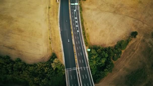 Nagranie z dronów powietrznych. samochody długodystansowe jadące po ruchliwej autostradzie we Włoszech. Pola uprawne i wzgórza w tle — Wideo stockowe