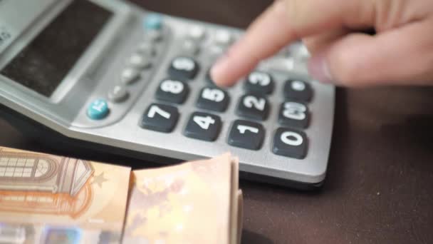 La mano masculina cuenta los gastos o ingresos en una calculadora — Vídeos de Stock