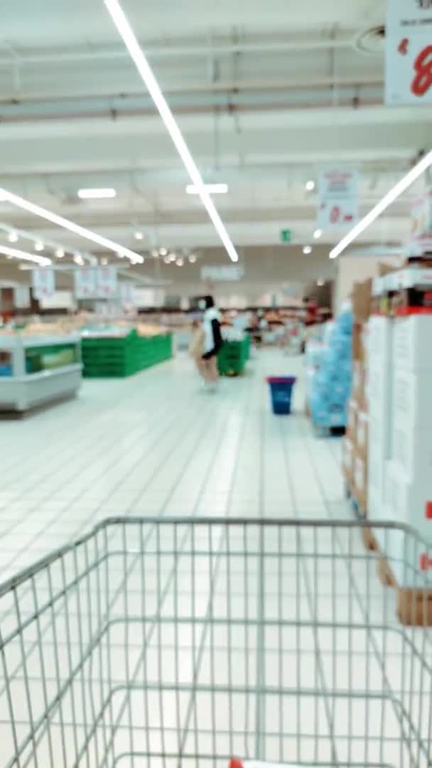 Deconcentratie. mensen lopen rond in de supermarkt. verticale video — Stockvideo