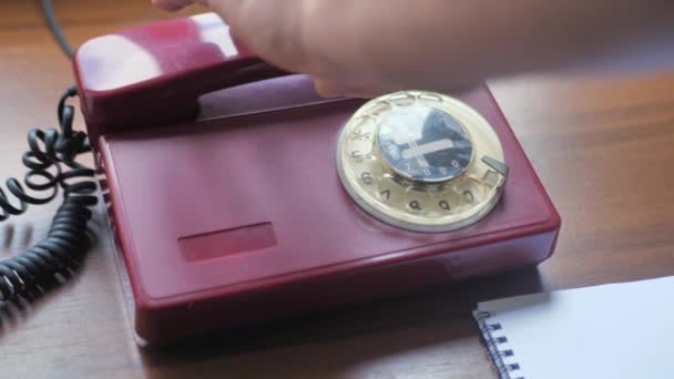 Vista de cerca de una mano recogiendo el receptor de teléfono un viejo teléfono giratorio. — Vídeos de Stock