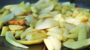 Adamın biri dışarıdaki ateşte patates kızartıyor. Arka bahçede kızartma tavası kampı.