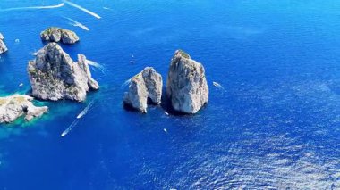 Muhteşem kayalık kayalıklar canlı turkuaz sulardan yükseliyor, güneşli kıyı şeridinin tadını çıkaran küçük teknelerle benekli. Huzurlu bir sahne doğanın güzelliğini en iyi şekilde yakalar..