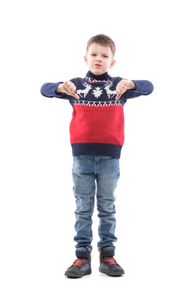 可爱的小男孩穿着圣诞毛衣 大拇指垂下 在镜头前皱着眉头 很不高兴 全身人像 白色背景隔离 — 图库照片