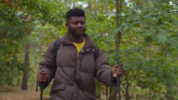 Afrikaanse man wandelen met wandelstokken in hout — Stockvideo