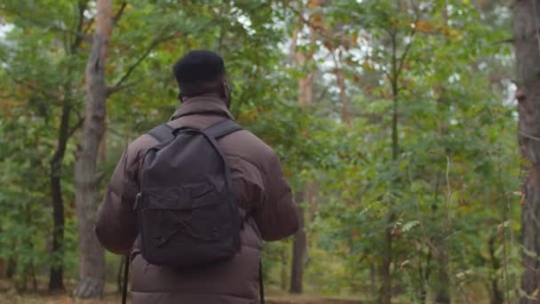 Африканський турист з рюкзаком подорожує лісом. — стокове відео