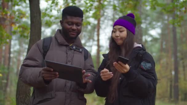 Touristes avec gadgets choisir la direction de la randonnée — Video