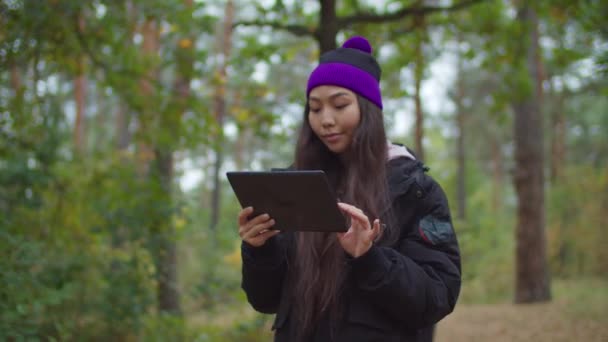 Asiatique femme randonneur avec tablette pc navigation dans le bois — Video