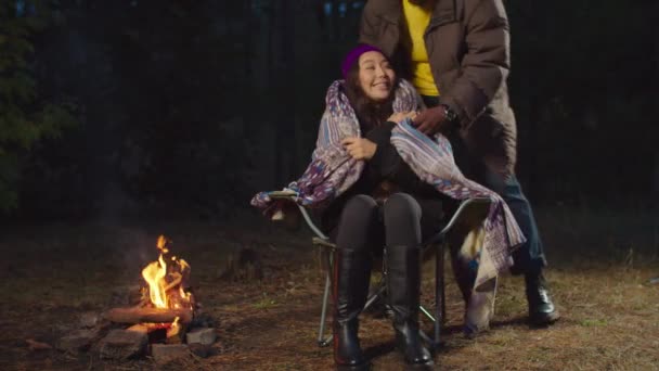 Homem cobrindo mulher fria com cobertor no acampamento — Vídeo de Stock