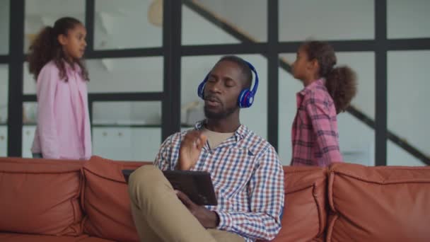 Dad in headphones ignoring scolding kids at home — Stock Video