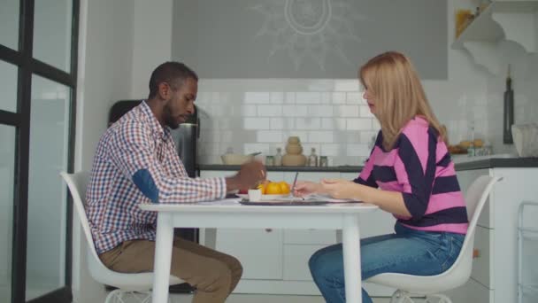 Pareja multiracial calculando facturas en cocina — Vídeos de Stock