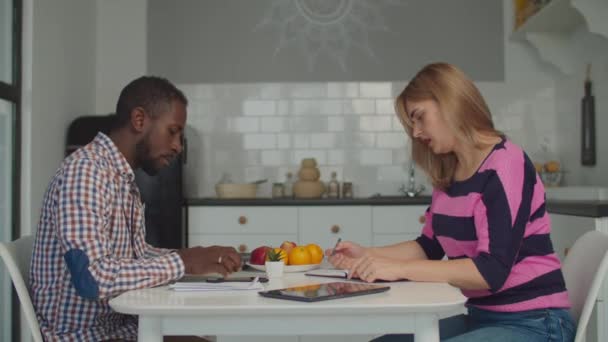 Casal diverso gerenciando orçamento familiar na cozinha — Vídeo de Stock