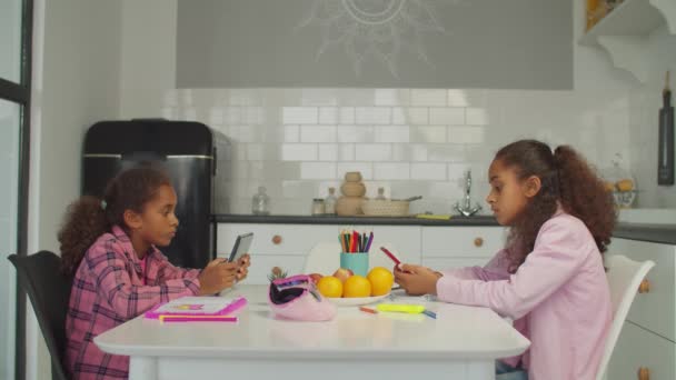 Little girls networking with gadgets in kitchen — Stock Video