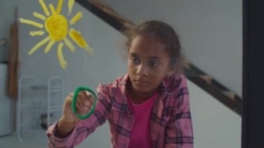 Pencere camında resim oluşturan küçük ressam