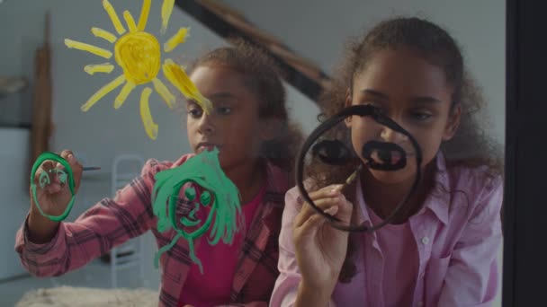 Lindas hermanas preadolescentes pintando familia en vidrio — Vídeos de Stock