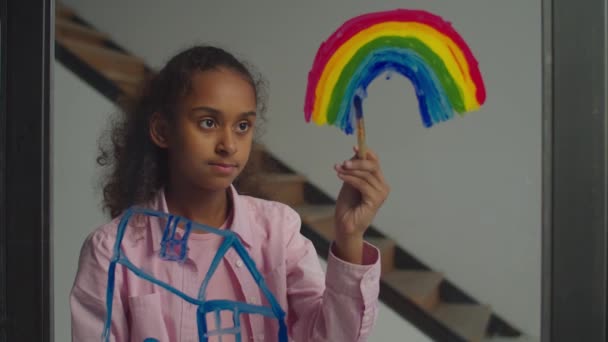 Precioso adolescente pintura arco iris en la ventana — Vídeos de Stock