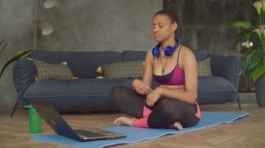 Sportif yogi siyah kadın lotus pozunda meditasyon yapıyor.