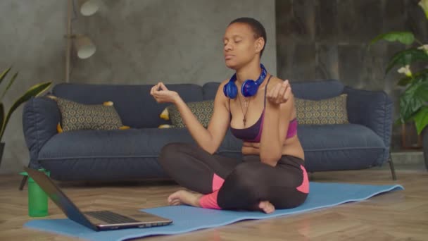 Spor zinde bir kadın evde yoga meditasyonu yapıyor. — Stok video