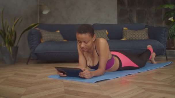 Female searching online fitness course on tablet pc — Αρχείο Βίντεο