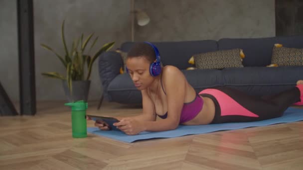 Привлекательная фитнес-женщина слушает музыку в помещении — стоковое видео
