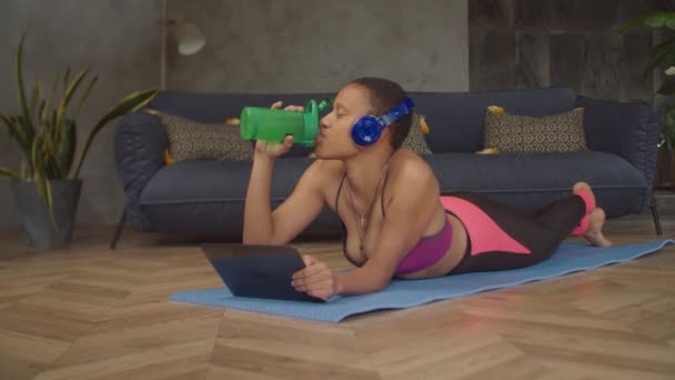 Mujer relajada bebiendo bebida energética después del entrenamiento — Vídeos de Stock