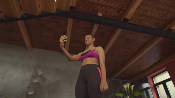 Fit femme avec téléphone portable accroupi pendant l'entraînement — Video