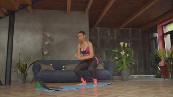 Desportivo preto feminino fazendo agachamentos exercício dentro de casa — Vídeo de Stock