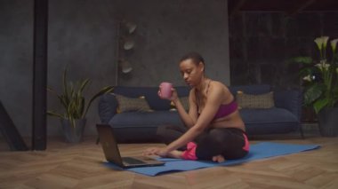 Yoga minderinde dizüstü bilgisayar üzerinde spor kadın ağı