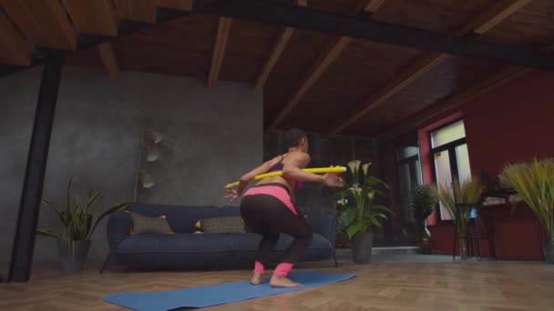 Achteraanzicht van fitte vrouw doet hurken met bar — Stockvideo