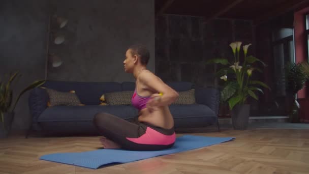 Femeie sportivă care face rotația trunchiului așezat cu bar — Videoclip de stoc