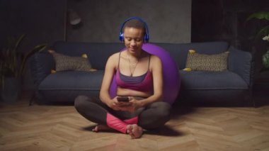 Sportif kadın evde telefonla mesaj atıyor.