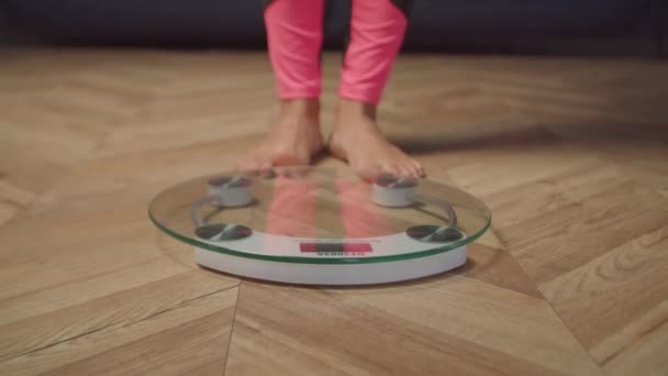 Descalço pernas femininas em pé na balança de pesagem — Vídeo de Stock