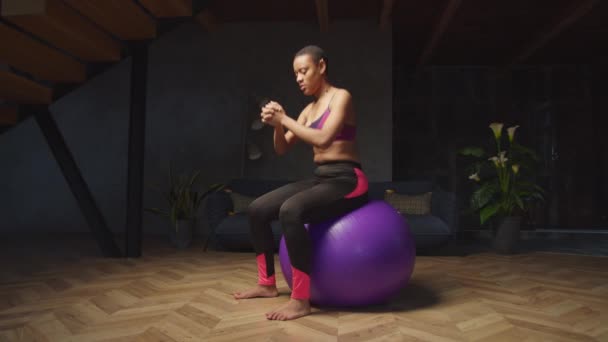 Cocok perempuan melakukan latihan memantul dasar pada fitball — Stok Video