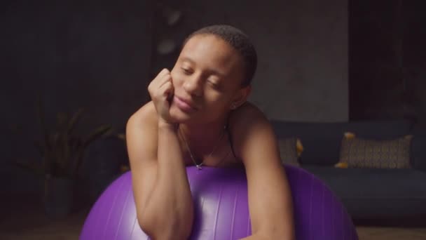 Portret van uitgeputte fitte vrouw rustend op fitball — Stockvideo