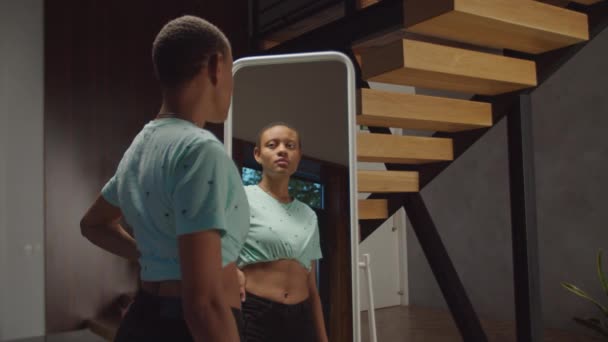 Уверенная женщина, проверяющая форму тела в зеркале — стоковое видео