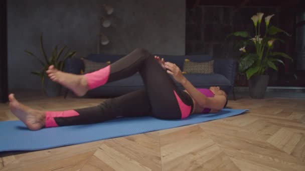 Donna in forma sportiva che pratica l'esercizio dal ginocchio al petto — Video Stock