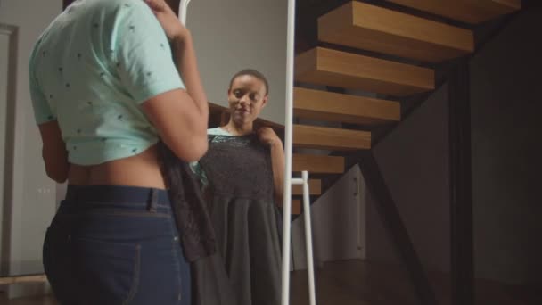 거울 앞에서 옷을 고르는 긍정적 인 여자 — 비디오