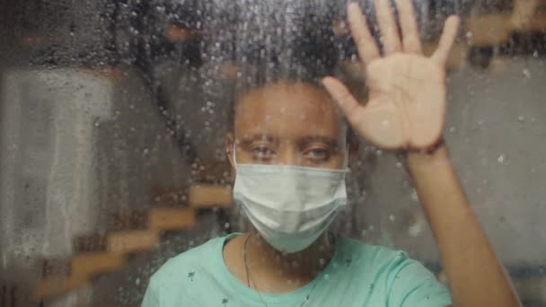 Μια μοναχική γυναίκα κοιτάζει έξω από το παράθυρο τις βροχερές μέρες. — Αρχείο Βίντεο