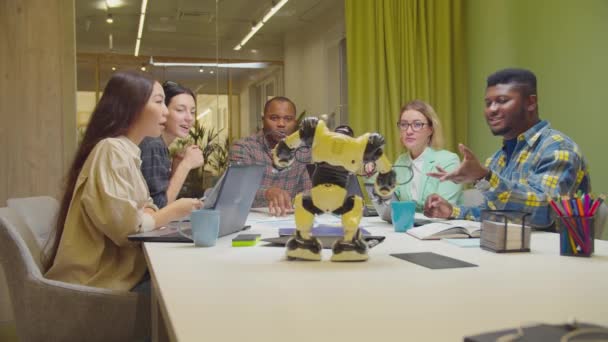 Equipo de ingenieros diversos discutiendo robot cibernético — Vídeo de stock