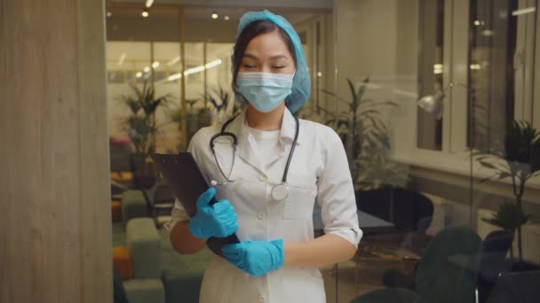 Pozytywny azjatycki lekarz uśmiecha się w szpitalu — Wideo stockowe
