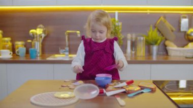 Plastik sofra takımıyla oynayan tatlı bir kız.