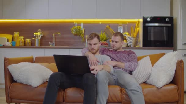 Homoseksualna para z laptopem na kanapie — Wideo stockowe