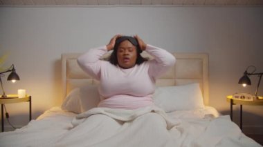 Uykulu tombul kadın esniyor ve uyuyor.