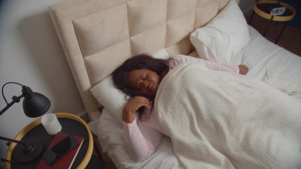 Schlafendes Weibchen deckt Ohren mit Kissen im Bett ab — Stockvideo