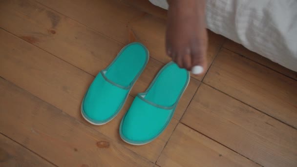 Vrouwelijke benen die 's morgens knusse pantoffels aantrekken — Stockvideo
