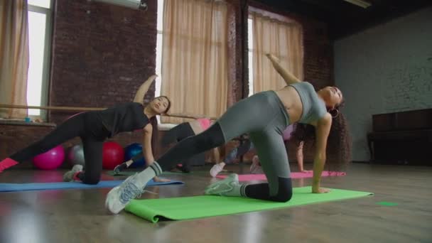 Multiétnico esportivo ajuste mulheres fazendo joelho lado prancha — Vídeo de Stock