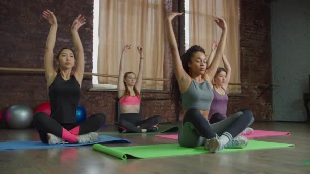Wieloetniczne kobiety ćwiczące jogę podczas oddychania — Wideo stockowe